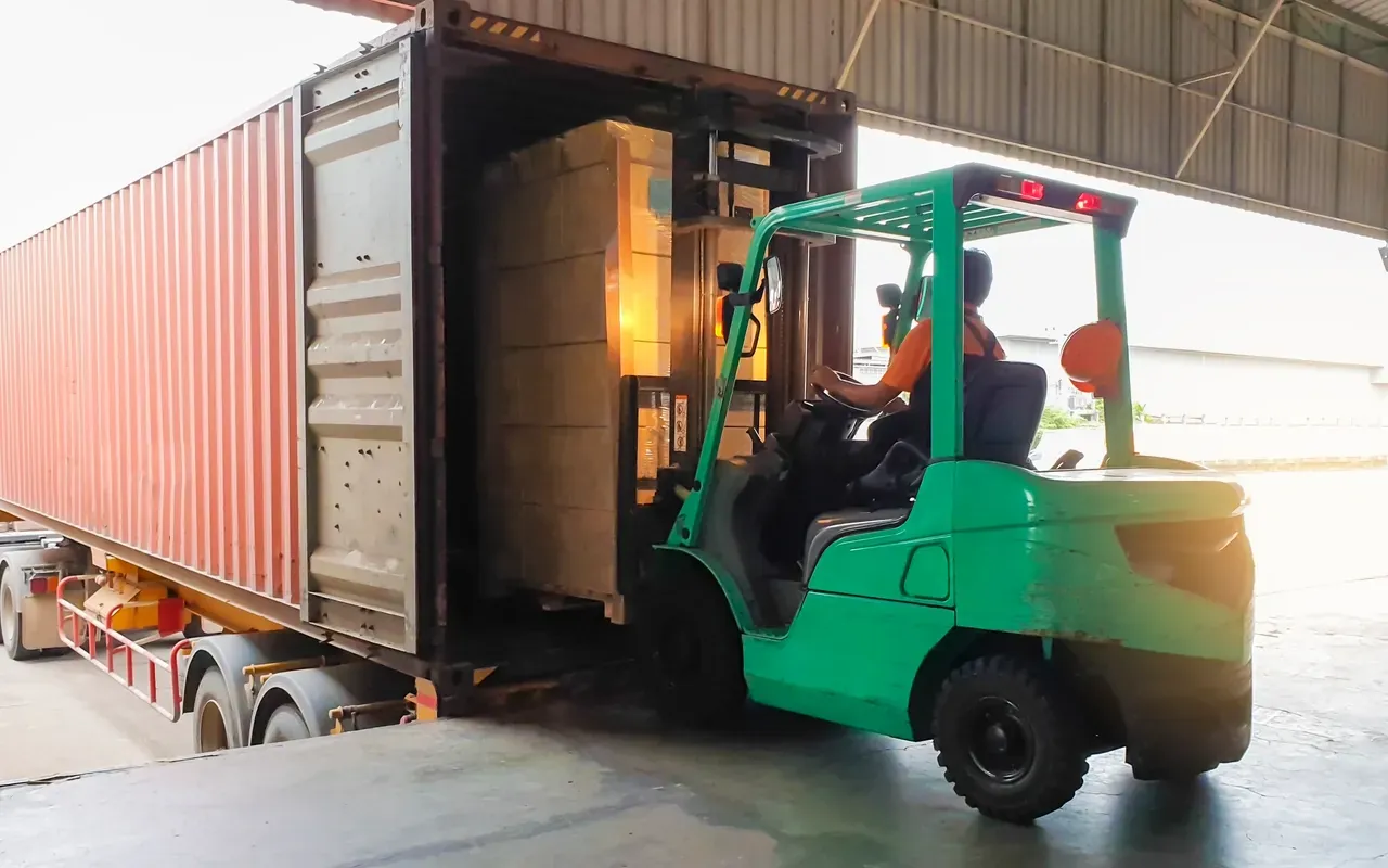 Forklift loading goods into a freight container